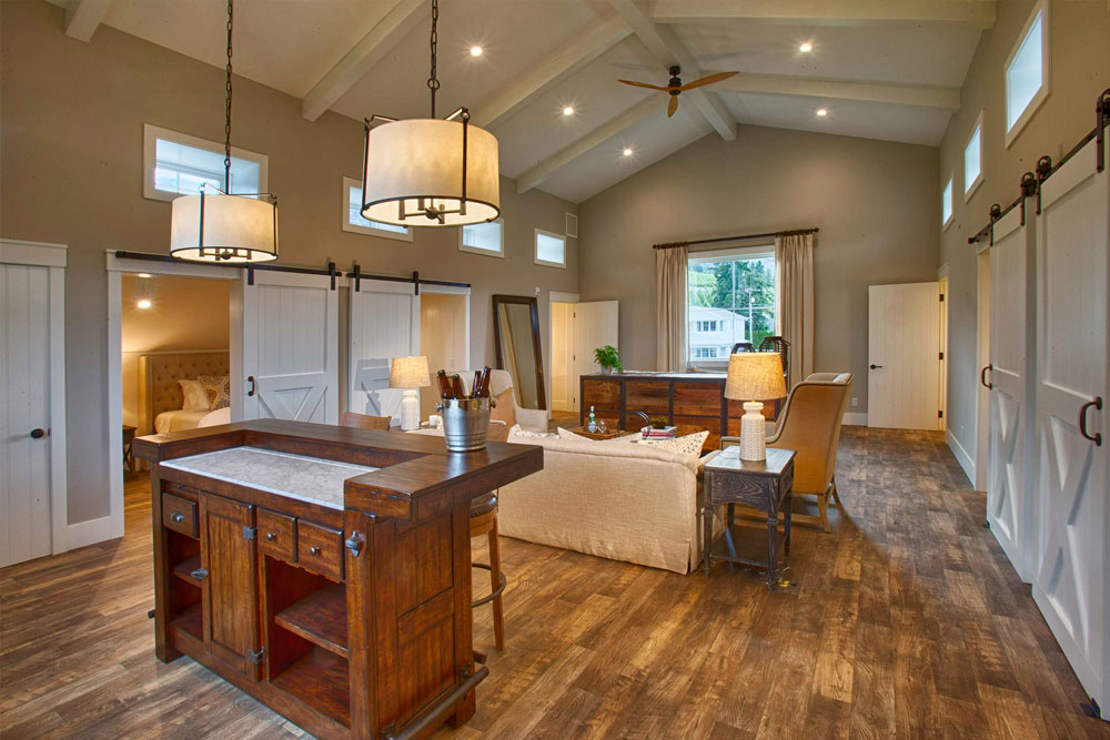 Warmly-lit photo of Harmony Meadow's Hayloft Suite. Gorgeous wood floors, comfortable seating, picture windows, and luxury finishes. 